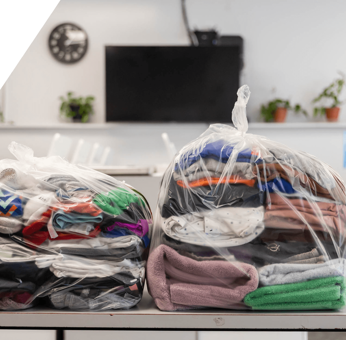 Clothes in plastic bags on table.